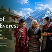 Sherpa people of Mount Everest in traditional dress near a Buddhist monastery with prayer flags and Himalayan peaks in Khumbu.